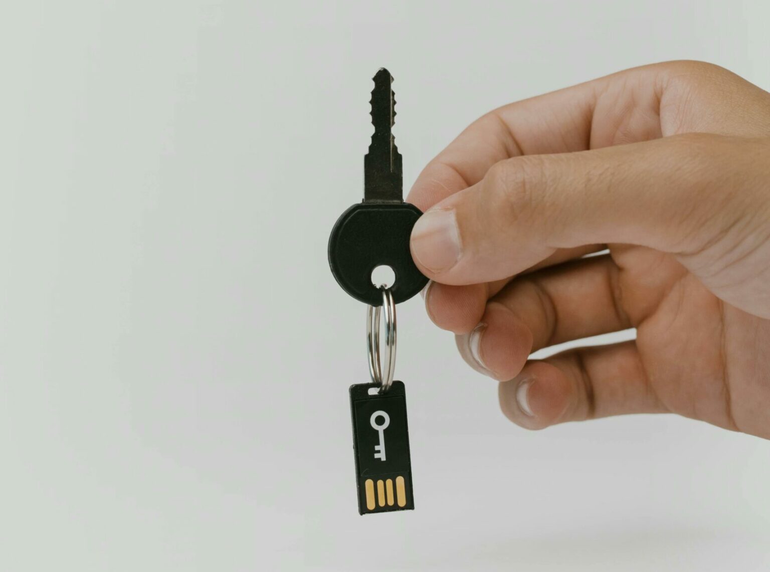Mano che tiene una chiave insieme a una chiavetta USB